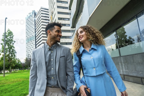 Diverse business professionals walking and smiling in a modern urban setting, conveying teamwork, partnership and confident, stylish collaboration for growth and success