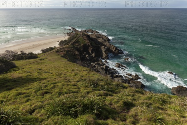 Sunlit daytime view with lookout platform below and glowing cliffs at Cape Byron, New South Wales, Australia