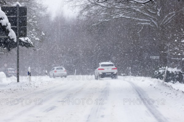 Road traffic in winter, cars driving on heavily icy roads covered with snow and black ice in snowstorms, risk of accident, Schleswig-Holstein, Germany