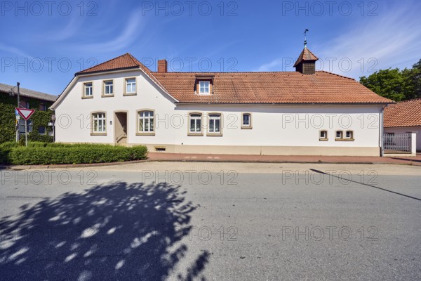 Historic residential building and commercial building, façade with windows, entrance, dormers, crested hipped roof, brick chimney, former textile shop, hedge, trees, blue sky, cirrus clouds, Campemoor Straße, Osnabrücker Straße, district of Vörden, Neuenkirchen-Vörden, district of Vechta, Lower Saxony, Germany