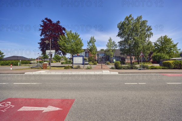 Neuenkirchen City Hall bus stop, town hall of the municipality of Neuenkirchen-Vörden, street, bicycle path, sidewalk, road marking cycle path, commercial building, modern architecture, trees, hedge, blue sky, cirrus clouds, Küsterstraße, Neuenkirchen-Vörden district, Vechta district, Lower Saxony, Germany