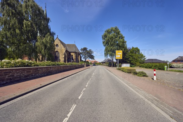 Church of the Apostle Church - Evangelical Lutheran parish Neuenkirchen-Vörden, general architecture, sidewalk, road, signpost, sandstone wall, trees, blue sky, cirrus clouds, Küsterstraße, Neuenkirchen-Vörden district, Vechta district, Lower Saxony, Germany