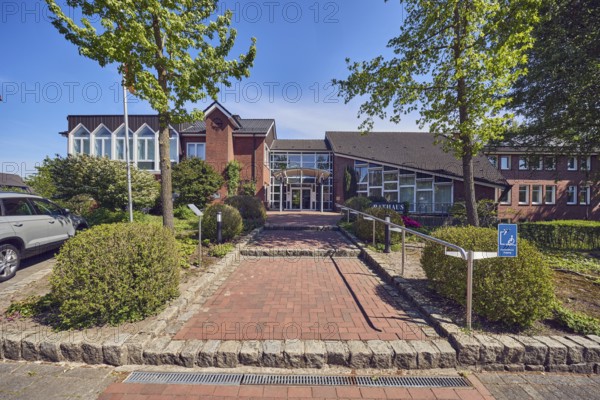 Town hall of the municipality of Neuenkirchen-Vörden, commercial building, modern architecture, entrance, façade with windows, glass façade, staircase, stainless steel railing, hedge, shrubs, trees, blue sky, cirrus clouds, Küsterstraße, Neuenkirchen-Vörden district, Vechta district, Lower Saxony, Germany