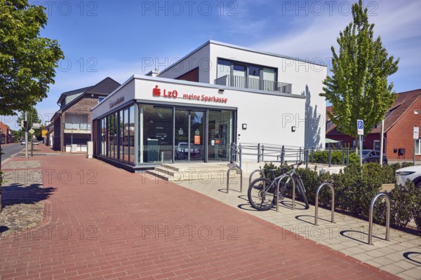 Landessparkasse zu Oldenburg, self-service foyer, commercial building, general architecture, paving brick pavement, bicycle rack with bicycle, trees, blue sky, cirrus clouds, Osnabrücker Straße, district of Vörden, Neuenkirchen-Vörden, district of Vechta, Lower Saxony, Germany