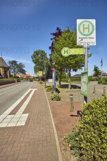 Bus stop Neuenkirchen Town Hall, general architecture, church, flagpoles, flags, sidewalk, street, bushes, trees, blue sky, cirrus clouds, Küsterstraße, Neuenkirchen district, Neuenkirchen-Vörden, district of Vechta, Lower Saxony, Germany