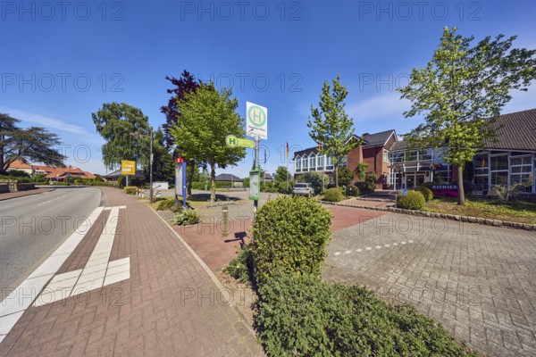 Neuenkirchen City Hall bus stop, town hall of the municipality of Neuenkirchen-Vörden, general architecture, flagpoles, flags, sidewalk, street, bushes, trees, blue sky, cirrus clouds, Küsterstraße, Neuenkirchen-Vörden district, Vechta district, Lower Saxony, Germany