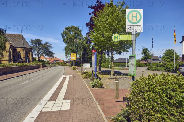 Bus stop Neuenkirchen Town Hall, general architecture, church, flagpoles, flags, sidewalk, street, bushes, trees, blue sky, cirrus clouds, Küsterstraße, Neuenkirchen district, Neuenkirchen-Vörden, district of Vechta, Lower Saxony, Germany