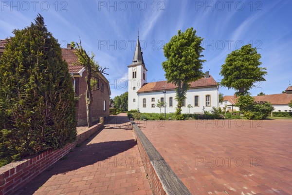 Ev. Church -Luth. parish of Vörden, church tower, general architecture, paving brick walkway, trees, blue sky, cirrus clouds, Große Hinterstraße, district of Vörden, Neuenkirchen-Vörden, district of Vechta, Lower Saxony, Germany