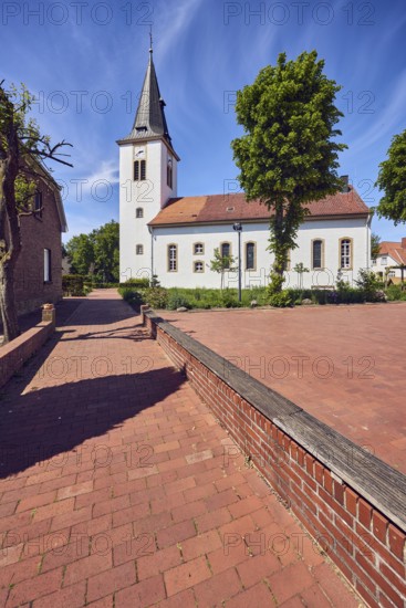 Ev. Church -Luth. parish of Vörden, church tower, general architecture, paving brick walkway, trees, blue sky, cirrus clouds, Große Hinterstraße, district of Vörden, Neuenkirchen-Vörden, district of Vechta, Lower Saxony, Germany