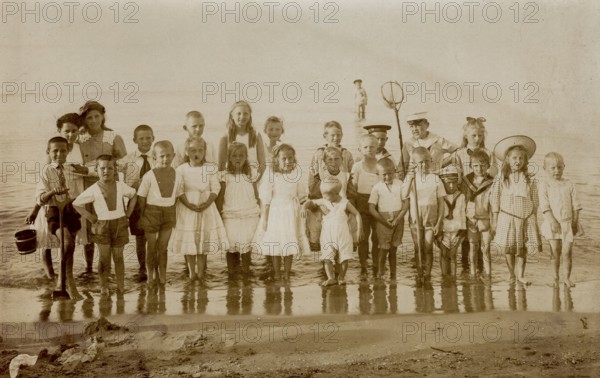 Digitally restored historical photograph of a large group of children on the Baltic Sea beach of Göhren on the island of Rügen, taken around 1924, Germany