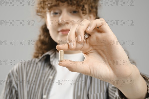Close up view of female hand with vitamin or supplements