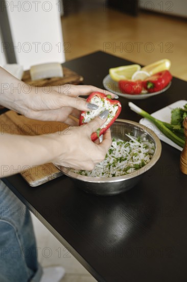 Female fingers pressing the cheese filling into bell pepper