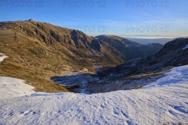 Deep snowy valley in the mountains with clear blue sky in the distance, winter, Route de Cretes, Hohneck, La Bresse, Vosges, France