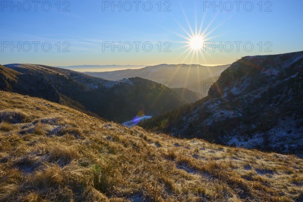 Sunrise over a snowy valley with rays of light and clear sky, morning, winter, Hohneck, La Bresse, Vosges, France