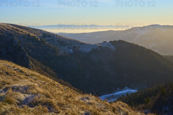 View of a snowy mountain range at sunrise with fog in the valley, morning, winter, Hohneck, La Bresse, Vosges, France