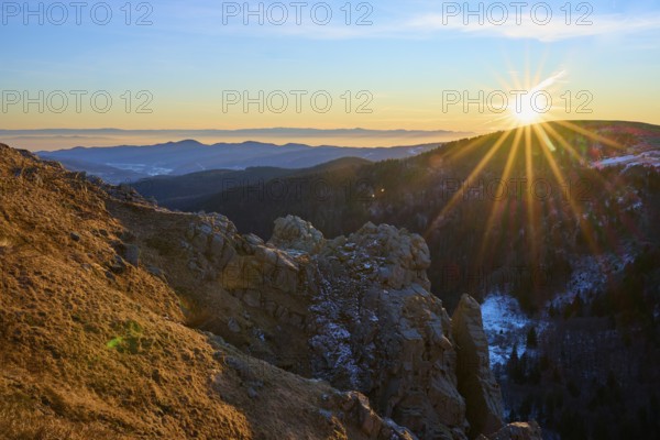 View of a rock formation illuminated by the low sun in the mountains, looking towards the Rhine Valley, viewpoint, La gorge de Pierrel, Martinswand, Frankental, Vosges, France
