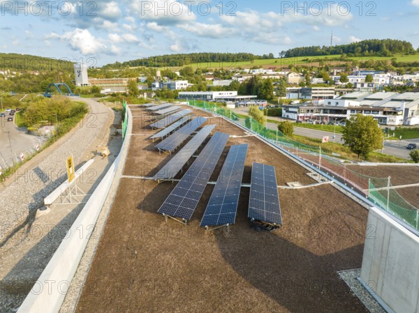 Row of solar modules on a sloping roof in an urban landscape, new park and ride parking garage Calw Heumaden on the new Hermann Hessebahn, Calw, Germany