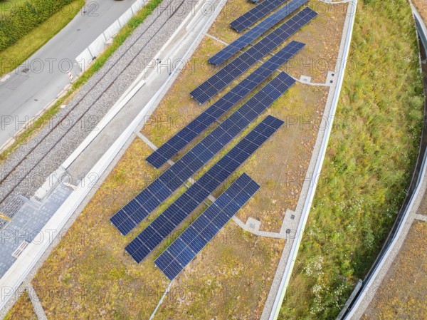 Close-up of solar panels on a green hill in urban surroundings, new park and ride car park Calw Heumaden on the new Hermann Hessebahn, Calw, Germany