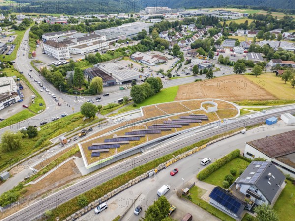 Aerial view of solar panels on a hill surrounded by urban infrastructure, new park and ride car park Calw Heumaden on the new Hermann Hessebahn, Calw, Germany