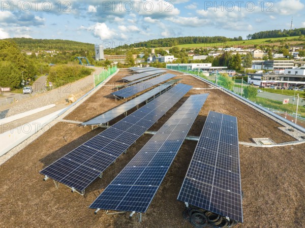 Arrangement of solar modules in a rural area with houses and hills, new park and ride parking garage Calw Heumaden on the new Hermann Hessebahn, Calw, Germany