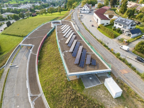 House roof with several solar panels surrounded by green landscape, new park and ride parking garage Calw Heumaden on the new Hermann Hessebahn, Calw, Germany