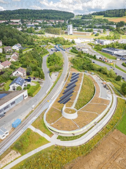 High view of a hilly landscape with solar panels and surrounding residential buildings, new Park and Ride parking garage Calw Heumaden on the new Hermann Hessebahn, Calw, Germany