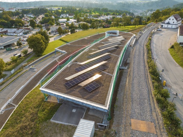 A large roof with solar panels, along a road in a green landscape, new park and ride parking garage Calw Heumaden on the new Hermann Hessebahn, Calw, Germany