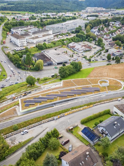 Overview of solar panels on a hill in an urban area with surrounding roads, new park and ride parking garage Calw Heumaden on the new Hermann Hessebahn, Calw, Germany