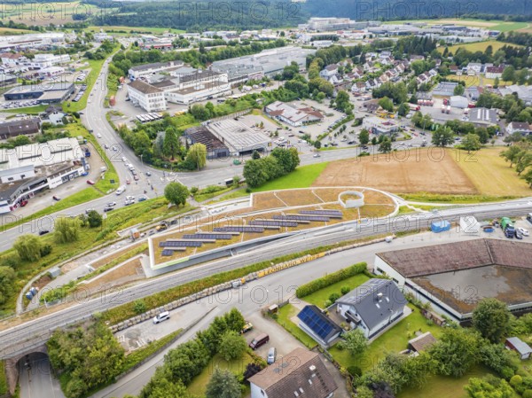 City panorama with solar systems on a hill in the middle of industrial buildings, new park and ride parking garage Calw Heumaden on the new Hermann Hessebahn, Calw, Germany