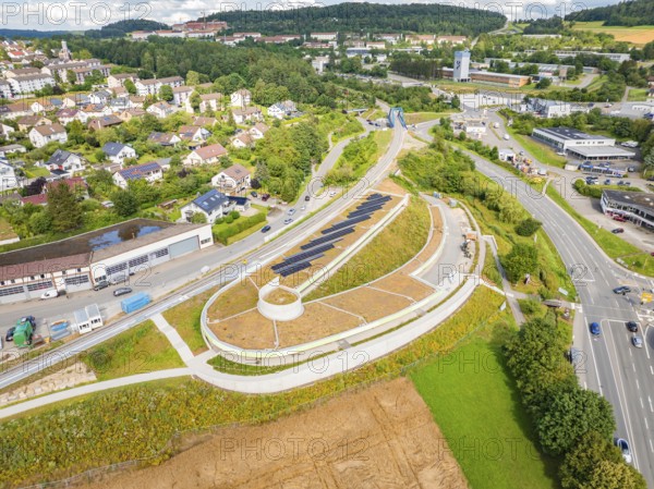 Wide city view with solar panel system and dense vegetation, new park and ride car park Calw Heumaden on the new Hermann Hessebahn, Calw, Germany