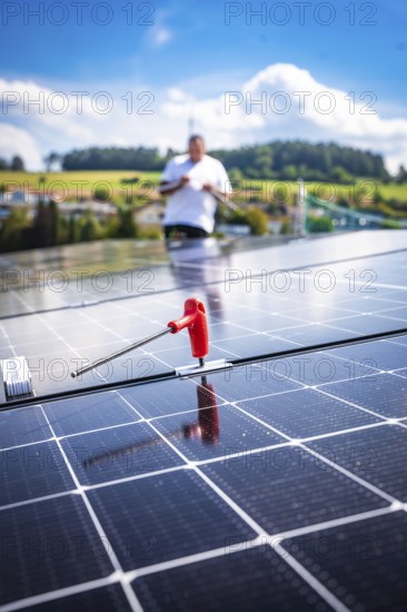 Close-up of a solar module with a working person in a rural area, new Park and Ride parking garage Calw Heumaden on the new Hermann Hessebahn, Calw, Germany