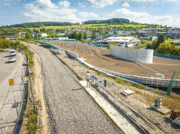 Large construction site for solar systems next to a village with green hills in the background, new Park and Ride Calw Heumaden car park on the new Hermann Hessebahn, Calw, Germany