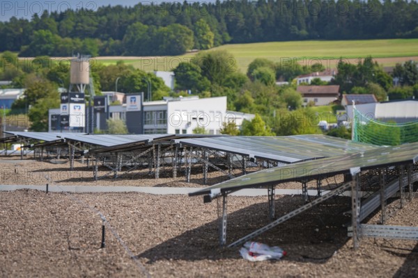 Solar panels on a roof with a view of a green landscape and nearby buildings, new park and ride parking garage Calw Heumaden on the new Hermann Hessebahn, Calw, Germany