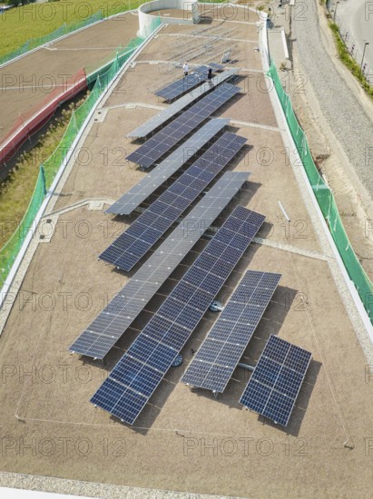 Solar panels on a roof viewed from above, surrounded by buildings, new park and ride parking garage Calw Heumaden on the new Hermann Hessebahn, Calw, Germany