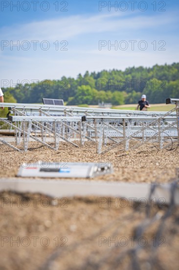 Workers prepare to install solar panels in an open field, new park and ride Calw Heumaden car park on the new Hermann Hessebahn, Calw, Germany