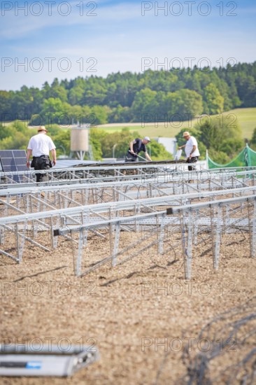 Several workers install solar panels on large racks in a scenic area, new Park and Ride Calw Heumaden car park on the new Hermann Hessebahn, Calw, Germany