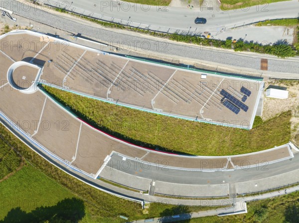 Aerial view of a green roof with solar panel and surrounding roads in urban surroundings, new park and ride parking garage Calw Heumaden on the new Hermann Hessebahn, Calw, Germany