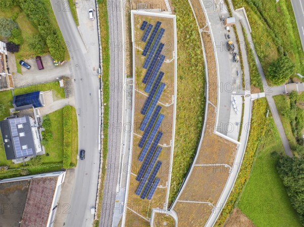 Aerial view of solar panels on a roof between roads in an urban area, new park and ride parking garage Calw Heumaden on the new Hermann Hessebahn, Calw, Germany