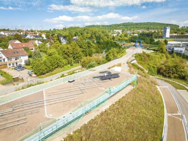 Overview of a village with a solar system in the neighborhood under blue skies, new Park and Ride parking garage Calw Heumaden on the new Hermann Hessebahn, Calw, Germany