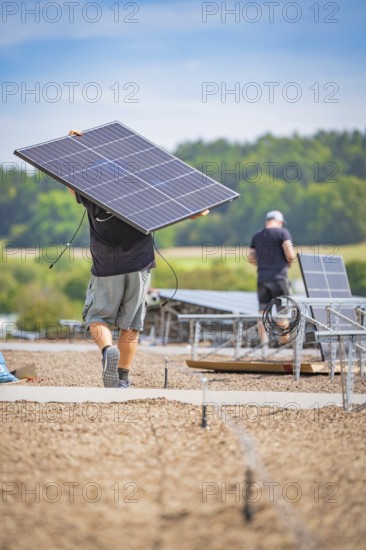 Workers transport and install solar panels in the open air, new park and ride Calw Heumaden car park on the new Hermann Hessebahn, Calw, Germany