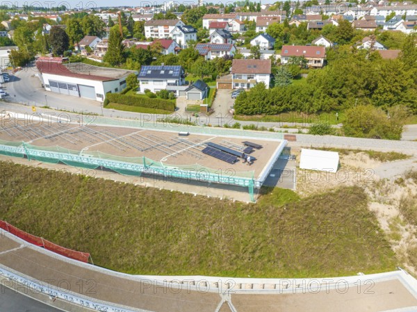 View of a solar panel in an urban area with houses and green surroundings, new park and ride parking garage Calw Heumaden on the new Hermann Hessebahn, Calw, Germany