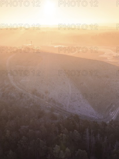 Foggy landscape at sunrise with a large hill, old deposit, construction site for PV open space plant, Lindenrain, Calw, Germany