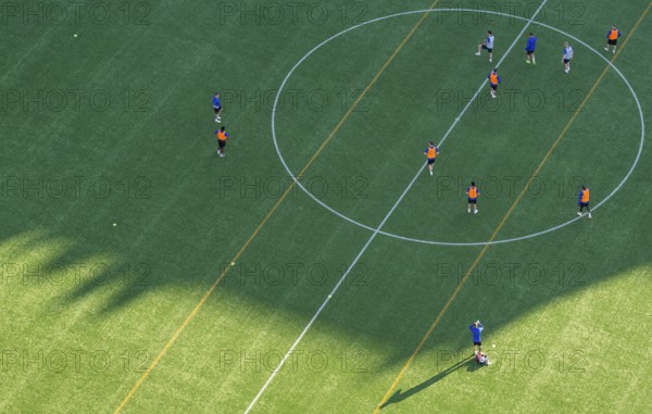 Players wearing colorful jerseys play soccer on a grass field from a bird's eye view from the tower of Helsinki Olympic Stadium, Finland