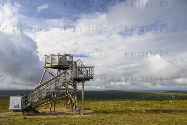 Wooden observation tower in a vast landscape under a partly cloudy sky, Kaunispää Caabuaivas, Lapland, Finland