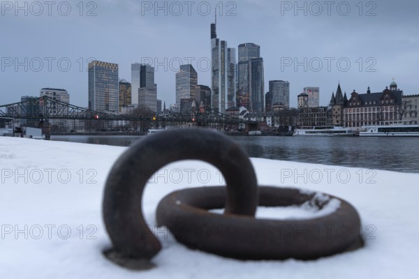 The towers of the Frankfurt banking skyline rise behind the snow-covered banks of the Main, Frankfurt am Main, Hesse, Germany