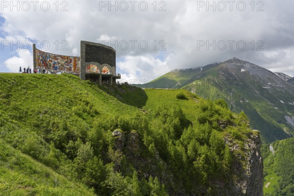 Cliffs with green vegetation and wall paintings, impressive natural scenery, Georgian-Russian Friendship monument, observation deck, between Gudauri and the Cross Pass, Mtskheta-Mtianeti region, Georgian Military Highway, High Caucasus, Georgia