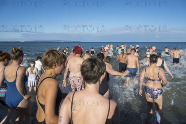 Swimmers run into water to bathe, tourist attraction Binzer Abbaden, Binz, seaside resort, Rügen island, Mecklenburg-Western Pomerania, Germany