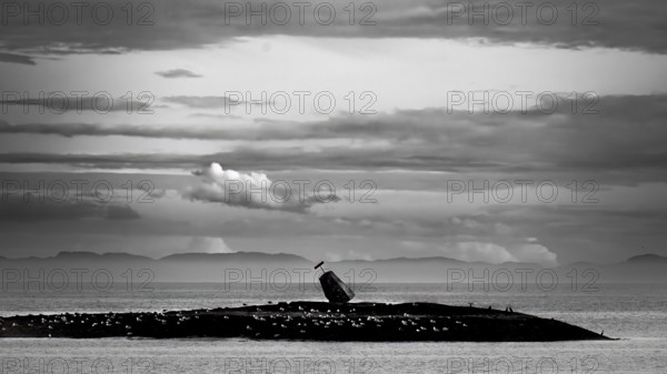 Kiberg, Troms, Norway, A sea mark on a rock in the sea in a dramatic black and white photo