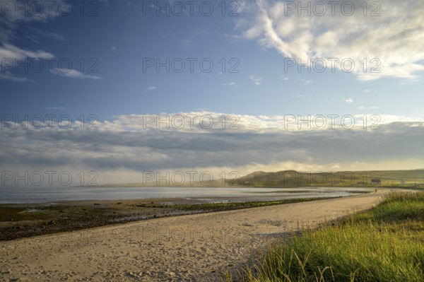 Idyllic morning atmosphere on a coast with beach, grass and wide sky on the beach of Kiberg, Troms, Norway