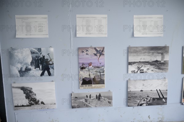 Wall with war pictures and documents in black and white in the partisan museum in the old school of Kiberg on a wooden wall, Kiberg, Troms, Norway